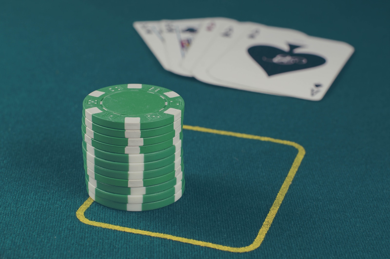 green poker chips on table ไพ่แคง