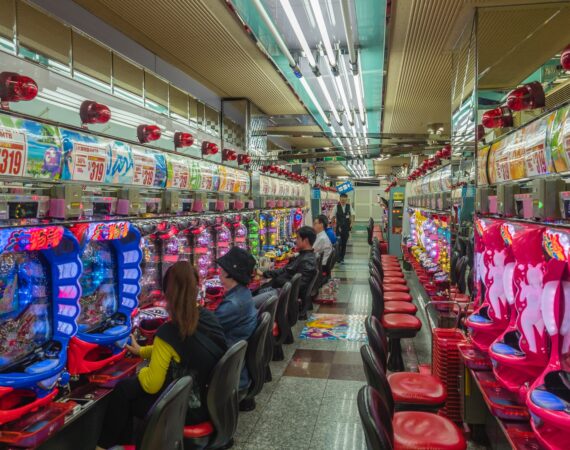 people sitting on red plastic chairs inside building