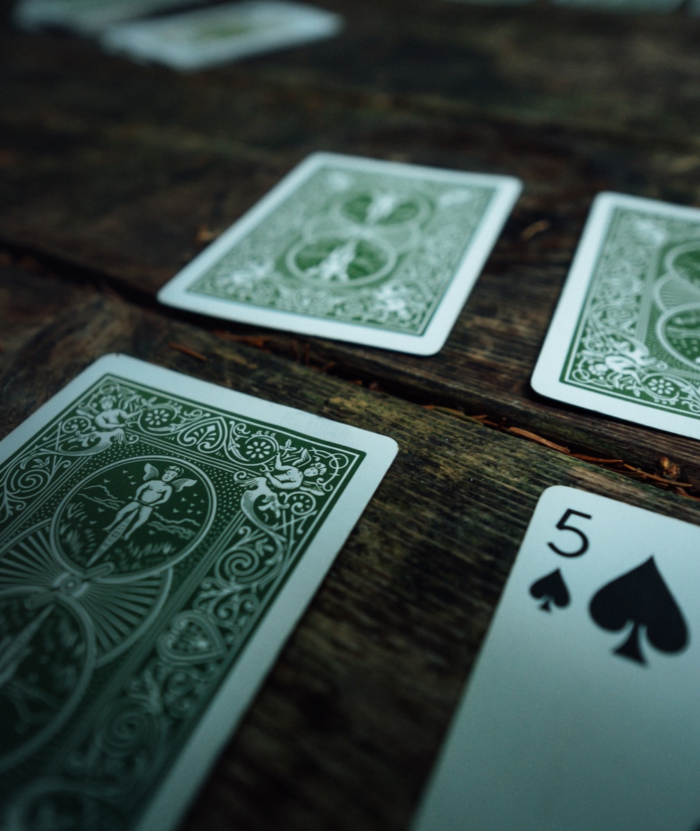 ไพ่แคง เกมมือถือยอดนิยมที่ใครหลายคนหลงรัก 2 5 of spades playing opened on brown wooden surface